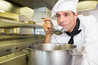 Male cook tasting food in kitchen