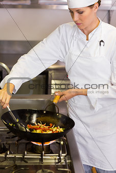 Concentrated female chef preparing food