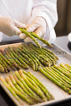 Hands with fresh asparagus in kitchen