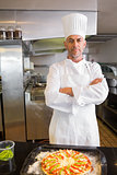 Confident male chef with cooked food in kitchen