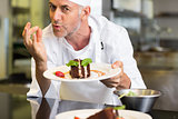 Smiling male pastry chef with dessert in kitchen