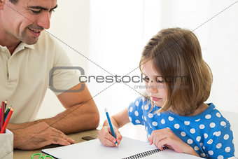 Father looking at daughter coloring
