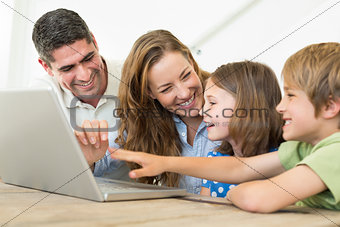 Cheerful family using laptop