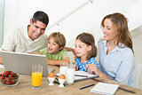 Family using laptop while having breakfast