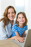 Girl and mother using laptop