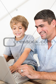 Father reaching son to use laptop