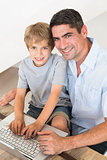 Happy father and son using laptop