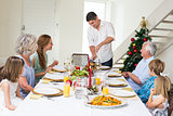 Father serving Christmas meal to family