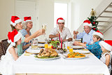 Family toasting wine while having Christmas meal