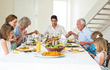 Family praying together before meal at dining table