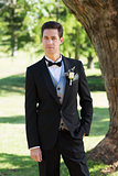 Confident bridegroom in tuxedo at garden