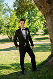 Handsome groom standing in garden