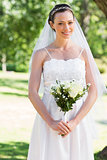 Bride holding bouquet in park