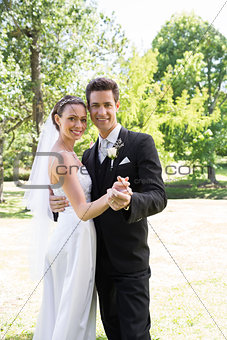 Newly wed couple dancing in garden