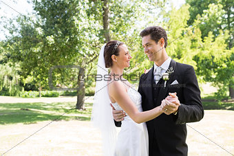 Loving bride and groom dancing in garden