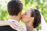 Young bride kissing groom on cheek