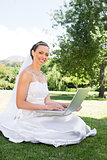 Bride using laptop in garden