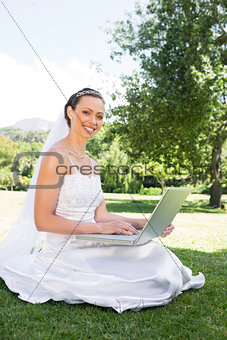 Bride using laptop in garden
