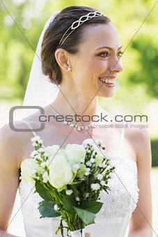 Young bride with flower bouquet in garden