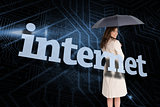 Businesswoman holding umbrella behind the word internet