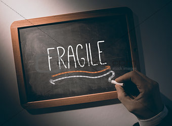 Hand writing Fragile on chalkboard