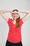 Smiling attractive woman through finger goggles