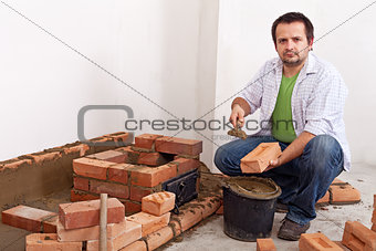 Man building a brick stove or fireplace