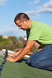 Man on the roof fastening bitumen roof shingles