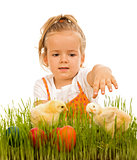 Little girl reaching for the eatser eggs and little chickens