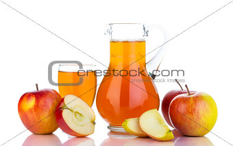 Fresh red apples, glass with juice and carafe