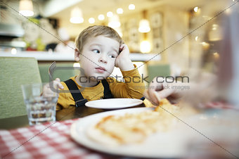 Bored little boy in a restaurant