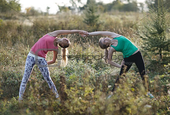 Two supple young women working out together