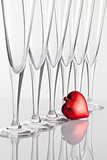 Six glasses of champagne and red heart on a glass table