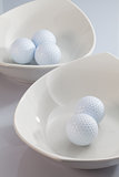White ceramics bowls and golf balls