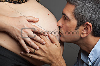 Man kissing wife's belly