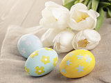 pastel color easter eggs with tulips on table