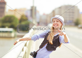 Happy young hipster pointing in camera outdoors
