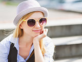 Portrait of young hipster sitting on bench in the city