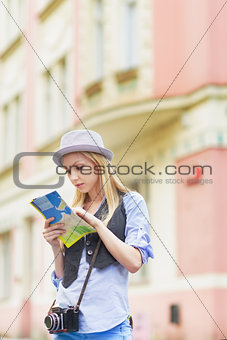 Young woman tourist with map in the city