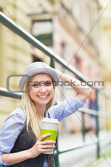 Young hipster enjoying cup of hot beverage in the city