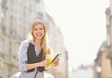 Happy young woman tourist with map in the city