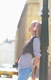 Relaxed young woman listening music in headphones in the city