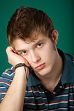 sad young guy on a green background