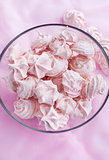 Pink meringues in a glass bowl