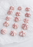 Pink meringues on baking paper