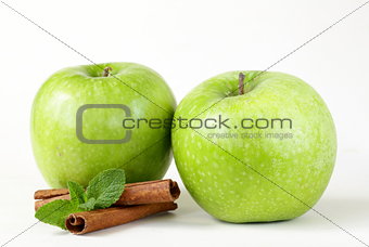 Granny Smith green apples with cinnamon and mint on a white background