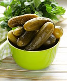 pickled cucumbers in green wooden bowl