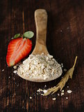 organic oat flakes with strawberries on a wooden table, a healthy diet