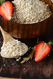 organic oat flakes with strawberries on a wooden table, a healthy diet