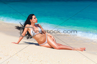 beautiful young brunette in bikini on a tropical beach